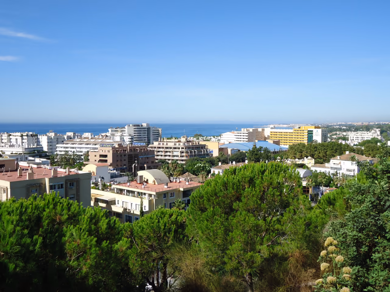 Elevated panoramic view across Marbella's urban area toward the Mediterranean Sea, shown as local context near VILLA IVORY